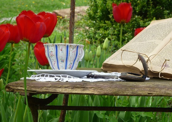 Bible with tulips, cup and glasses